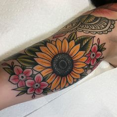 a woman's arm with a sunflower tattoo on it