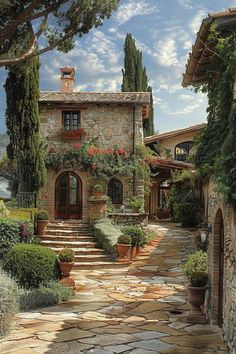 a stone house with steps leading up to it and flowers growing all over the front