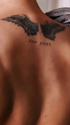 the back of a man with an angel wing tattoo on his chest