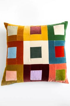 a multicolored patchwork pillow on a white background with the same color as it appears