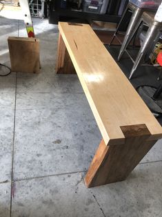 a wooden bench sitting on top of a cement floor