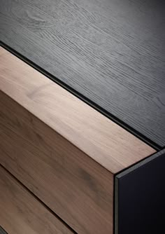 a close up of a wooden drawer with black and brown trim on the bottom part