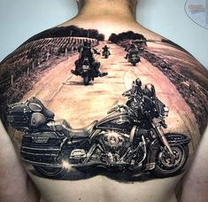 a man's back with two motorcycles on the road in front of him and another motorcycle behind him