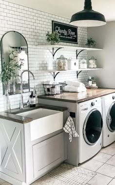 a washer and dryer in a room with white tiles on the walls,