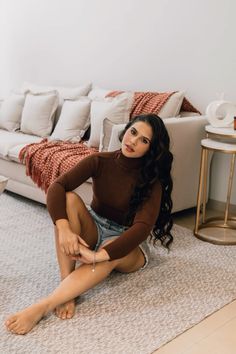 a woman sitting on the floor in front of a couch