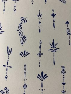 an image of blue ink on paper with arrows and flowers in it's design