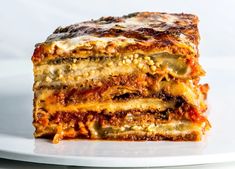 a stack of lasagna stacked on top of each other in a white plate