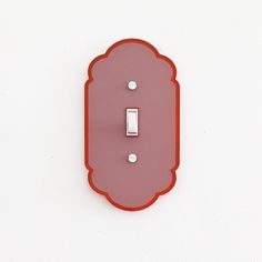 a red light switch cover on a white wall