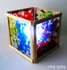 a colorful box made out of wood with paint splattered on it's sides