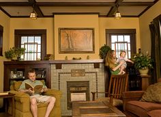 a man and woman sitting in a living room with a child on their lap reading a book