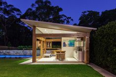 an outdoor kitchen and dining area are lit up at night