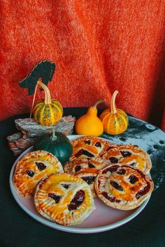 pies and gourds on a table with pumpkins