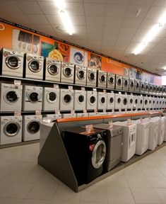 there are many washers and dryers on display in the store's laundry room