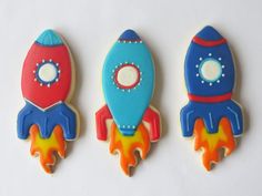 three decorated cookies in the shape of rockets