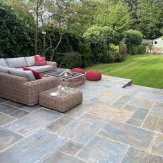 an outdoor living area with couches, tables and chairs in the middle of it