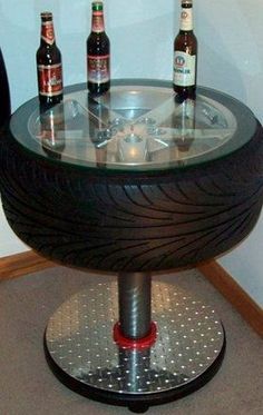 a table made out of an old tire with beer bottles on the top and bottom