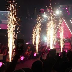 fireworks are lit up in the night sky at a concert