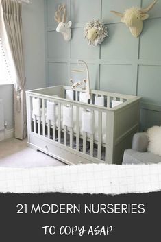 a baby's room with deer heads on the wall and white crib in the corner