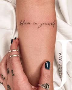 a woman's arm with the words believe in yourself tattooed on it