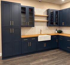 an empty kitchen with blue cabinets and wood flooring on the walls is seen in this image