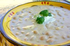 a yellow bowl filled with white beans and sour cream