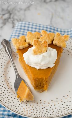 a slice of pumpkin pie with whipped cream and graham crackers on top, sitting on a plate