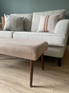 a white couch sitting on top of a hard wood floor next to a wooden table