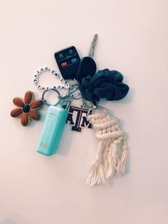 a key chain, cell phone and other items on a white surface