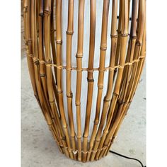 a large round wicker table with white and black stripes on the top, sitting on concrete