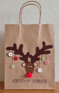 a brown paper bag with a reindeer head and christmas decorations on the front is sitting on a table