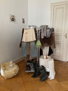 several pairs of shoes are hanging on a rack in a room with wooden floors and white walls