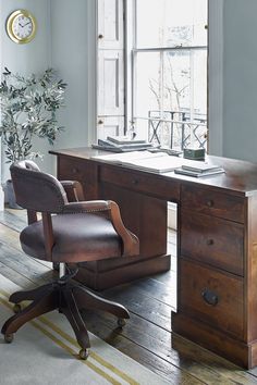 an office chair sitting in front of a wooden desk