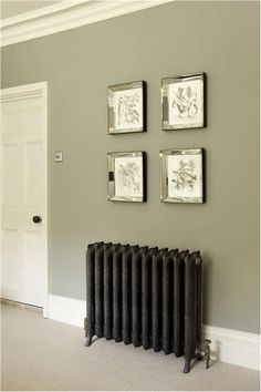 three framed pictures on the wall next to a radiator in a living room