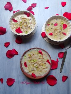 two bowls filled with food sitting on top of a table next to rose petal petals