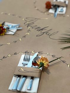 a place setting with napkins, forks and flowers