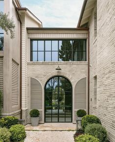 an entrance to a large brick building with arched windows and stone walkway leading up to the front door