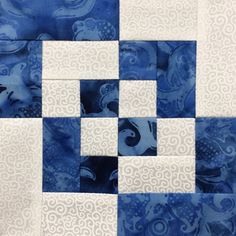 the blue and white quilt is made up of squares, which are arranged in different patterns