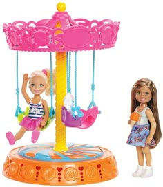 the doll is playing with her toy carousel