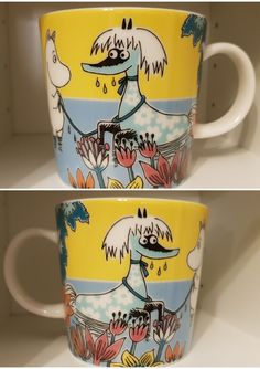 two coffee mugs with pictures of dogs and flowers on them, one is yellow and the other is blue