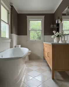 a bath room with a tub a sink and a window