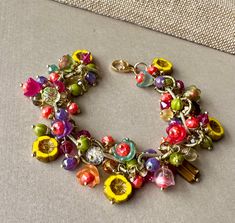 You can almost sniff the floral fragrance of this colorful beauty!  Bright, vibrant beads each individually wire wrapped onto a brass link chain.  Besutiful! Whimsical Multicolor Charm Bracelet Gift, Whimsical Colorful Beaded Bracelet, Junk Bracelets, Vintage Multicolor Jewelry With Flower Charm, Whimsical Multicolor Charms Jewelry, Whimsical Multicolor Necklaces With Charms, Oak Park Illinois, Jewelry 2024, Playful Jewelry