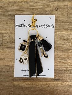 a keychain with a black dress on it and some charms attached to it