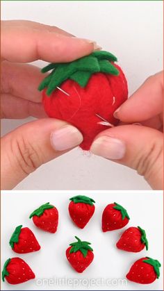 someone is holding a strawberry in their hands and it looks like they have been made out of felt