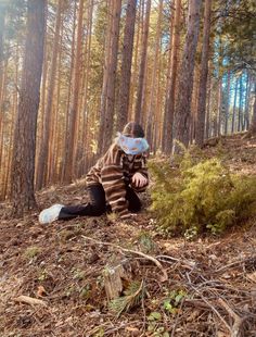 a person sitting in the woods wearing a face mask