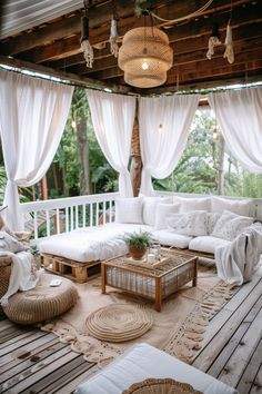 an outdoor living room with white curtains and wicker furniture