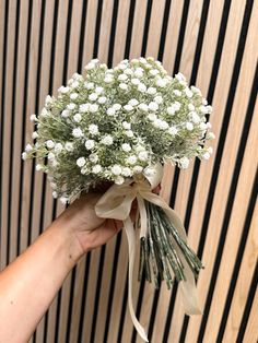 a hand holding a bouquet of white flowers