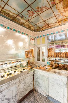 the interior of a bakery with painted ceilings and marble counter tops, along with many baked goods