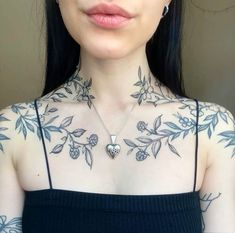 a woman with tattoos on her chest wearing a black top