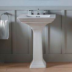 a white pedestal sink sitting next to a towel rack