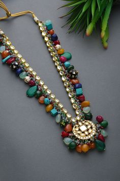 Multicoloured Navrattan Kundan Inspired Necklace with Earrings. This beautifully handcrafted necklace is set in silver and copper alloy and plated with 22k gold. This necklace with a twist of Pearl stones by Paisley Pop is a perfect accessory for an Indian Bride. Necklace Size - Length 16 inc, Width 1.5 inc Closure - Adjustable Thread Dori Style Tip - Wear this with almost anything Indian for a rich and royal look because nothing more regal than kundan necklace set. We love teaming this with cla Multicolor Temple Necklace For Rituals, Multicolor Fusion Temple Necklace For Festivals, Multicolor Fusion Kundan Necklace With Tilla, Multicolor Round Temple Jewelry Necklaces, Fusion Multicolor Meenakari Bridal Necklace, Multicolor Meenakari Fusion Bridal Necklace, Fusion Style Multicolor Meenakari Bridal Necklace, Handmade Long Beaded Necklaces For Festive Occasions, Handmade Long Beaded Necklace For Festive Occasions